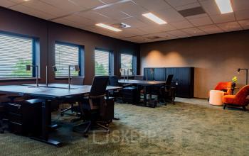 Office space at Reitschweg 1, Den Bosch, featuring furnished workstations with desks, chairs, and ample lighting, available for rent.