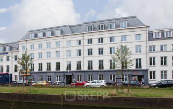 Modern office space rental at Koninginnegracht 19, The Hague Center, with a sleek facade reflecting a professional environment.