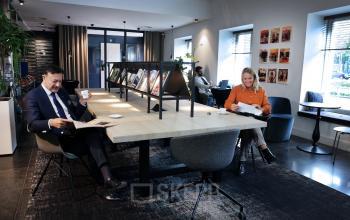 Modern office space at Koninginnegracht 19, The Hague Center, with professionals engaged in business activities for office space rental.