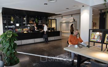 Modern lounge area in Koninginnegracht 19, The Hague Center, ideal for a casual office space rental, with individuals conducting business activities.