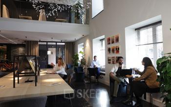 Modern office at Koninginnegracht 19 in The Hague Center with professionals engaged in work discussions, great for an office space rental.