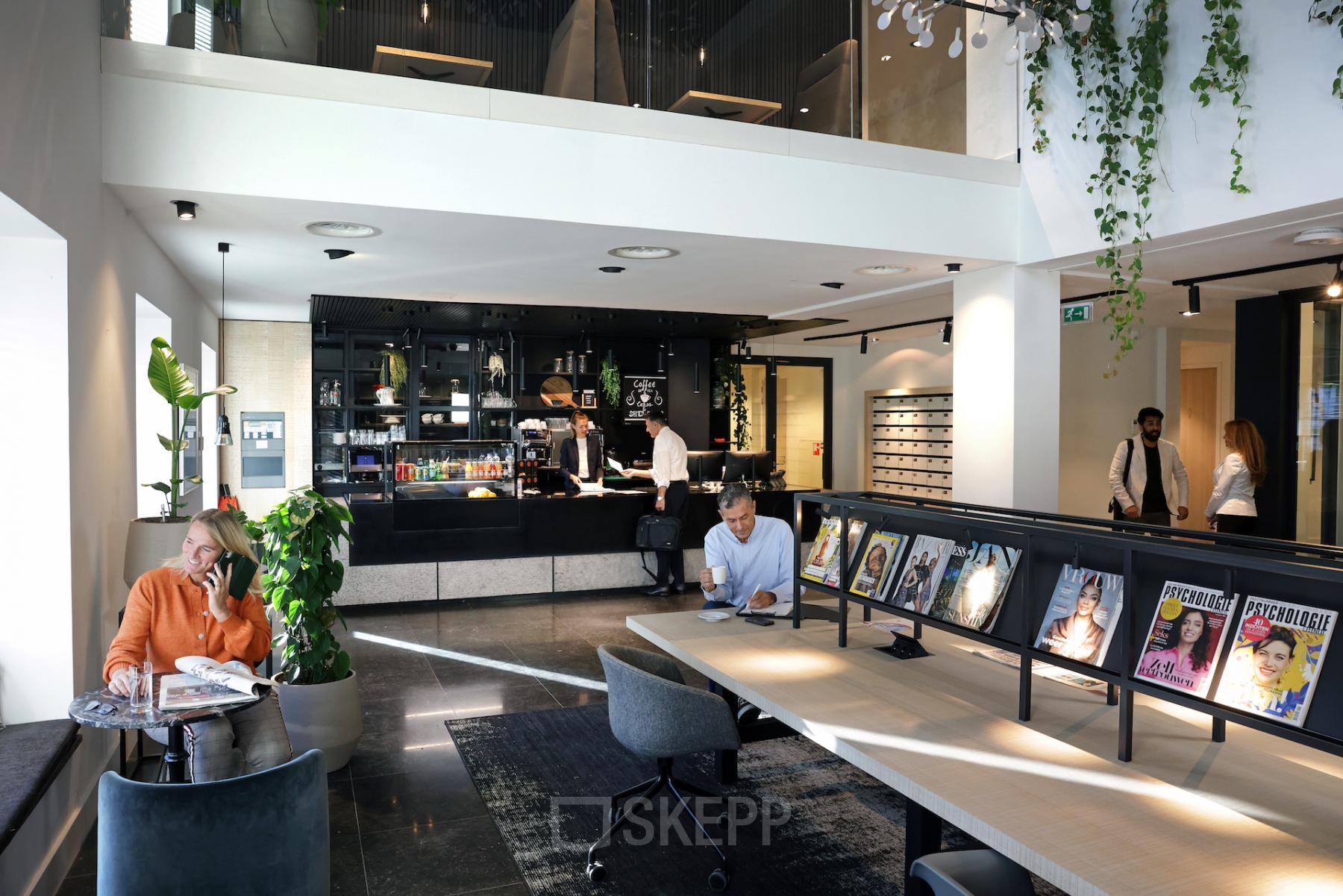 Contemporary office lounge at Koninginnegracht 19 with individuals engaged in business activities, ideal for an office space rental at The Hague Center.