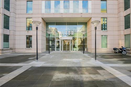 Entrance of an office building at Alexanderveld 5-9 in The Hague Center, showcasing a modern facade with large glass doors, ideal for office space rental.