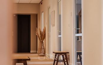 Modern office hallway at Zeestraat 100, The Hague Center, featuring wooden benches and soft lighting, ideal for office space rental.