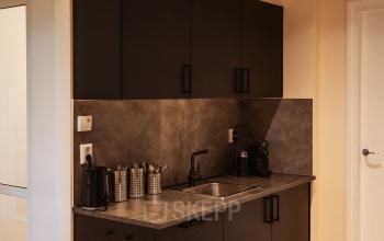 Compact pantry at Zeestraat 100, The Hague Center, ideal for office space rental, featuring a small sink, coffee machine, and storage.