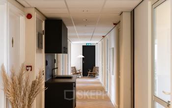 Hallway at Zeestraat 100 in The Hague Center with seating and natural decor, ideal for office space rental.