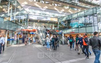 Busy entrance area at Koningin Julianaplein 10 with people moving through, perfect for finding an office to rent in The Hague Center.