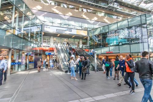 Busy entrance area at Koningin Julianaplein 10 with people moving through, perfect for finding an office to rent in The Hague Center.