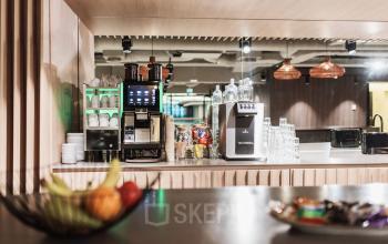 Cozy pantry area with a coffee machine, glassware, and fruit basket, ideal for office space rental needs in The Hague Center.