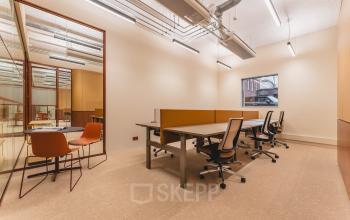 Modern office interior at Zeestraat 70, The Hague Center, featuring spacious workstations with contemporary desks and chairs, ideal for office space rental.