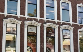 Exterior view of the office building at Zeestraat 70, The Hague Center, The Hague. The building features large windows and a central entrance with signage.
