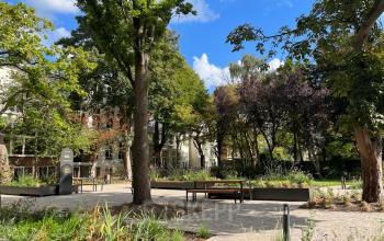 Exterior view of office building located at Zeestraat 70, The Hague Center, The Hague, featuring surrounding trees and garden.