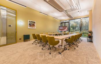 Modern meeting room at Zeestraat 70, The Hague Center featuring a large conference table, ergonomic chairs, and a screen for presentations, ideal for office space rental.