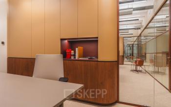 Modern office space at Zeestraat 70, The Hague Center, featuring sleek furnishings and bright lighting through glass partitions. Ideal for office space rental with dedicated work areas and contemporary design.