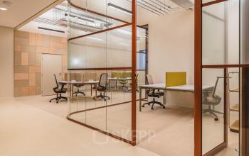 Modern office space with glass partitions, featuring ergonomic chairs and desks, ideal for collaboration. Located in The Hague Center's Zeestraat 70 for those seeking office space rental.