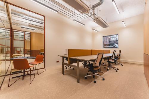 Modern office interior at Zeestraat 70, The Hague Center, featuring spacious workstations with contemporary desks and chairs, ideal for office space rental.