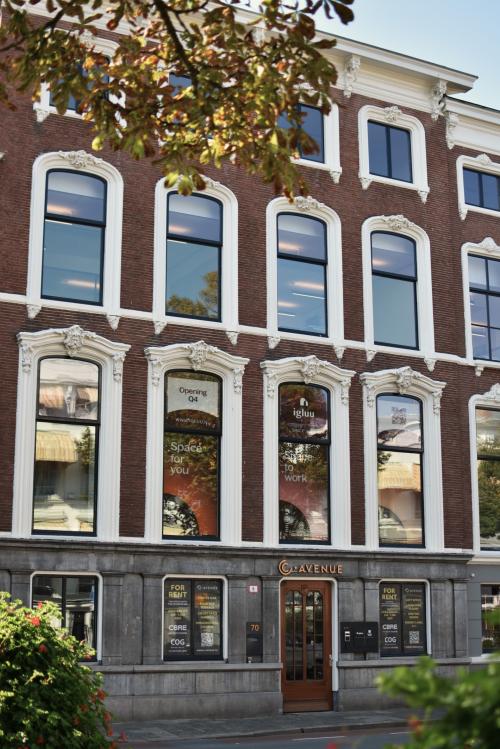 Exterior view of the office building at Zeestraat 70, The Hague Center, The Hague. The building features large windows and a central entrance with signage.