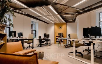 Spacious office to rent at Fluwelen Burgwal 58, The Hague Center, featuring furnished workspaces with desks and chairs under modern lighting.