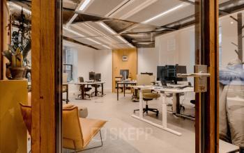 Modern office space with several desks and office chairs, computers set up, located at Fluwelen Burgwal 58 in The Hague Center, available for office space rental.