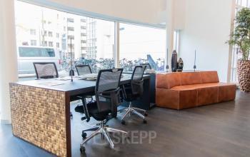 Modern office space with a meeting table, ergonomic chairs, and a leather sofa at Kalvermarkt 53, The Hague Center, The Hague.