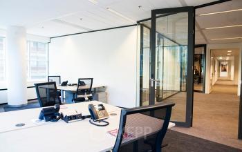 Modern office space rental at Kalvermarkt 53, The Hague Center, with desks, chairs, and partitioned areas for focused work.
