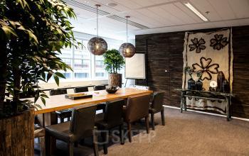 Elegant office space rental at Kalvermarkt 53, The Hague Center, featuring a sturdy wood table, comfortable seating, and tasteful decor.