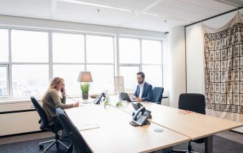 Professionals engaged in business activities in a well-lit office space rental at Kalvermarkt 53, The Hague Center.