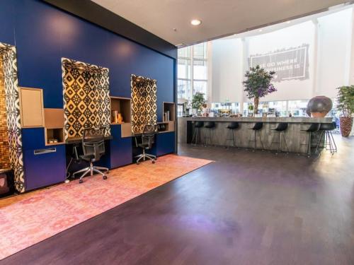 Stylish workspace interior at Kalvermarkt 53, The Hague Center, featuring modern workstations with patterned panels and bar seating area.