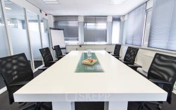 A modern conference room at Platinaweg 25, The Hague Escamp, ideal for office space rental with a sleek white table and black chairs.