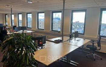 Spacious office to rent at Platinaweg 10, The Hague Escamp, featuring multiple desks with computers and views of the city. Ideal for flexible office space rental.