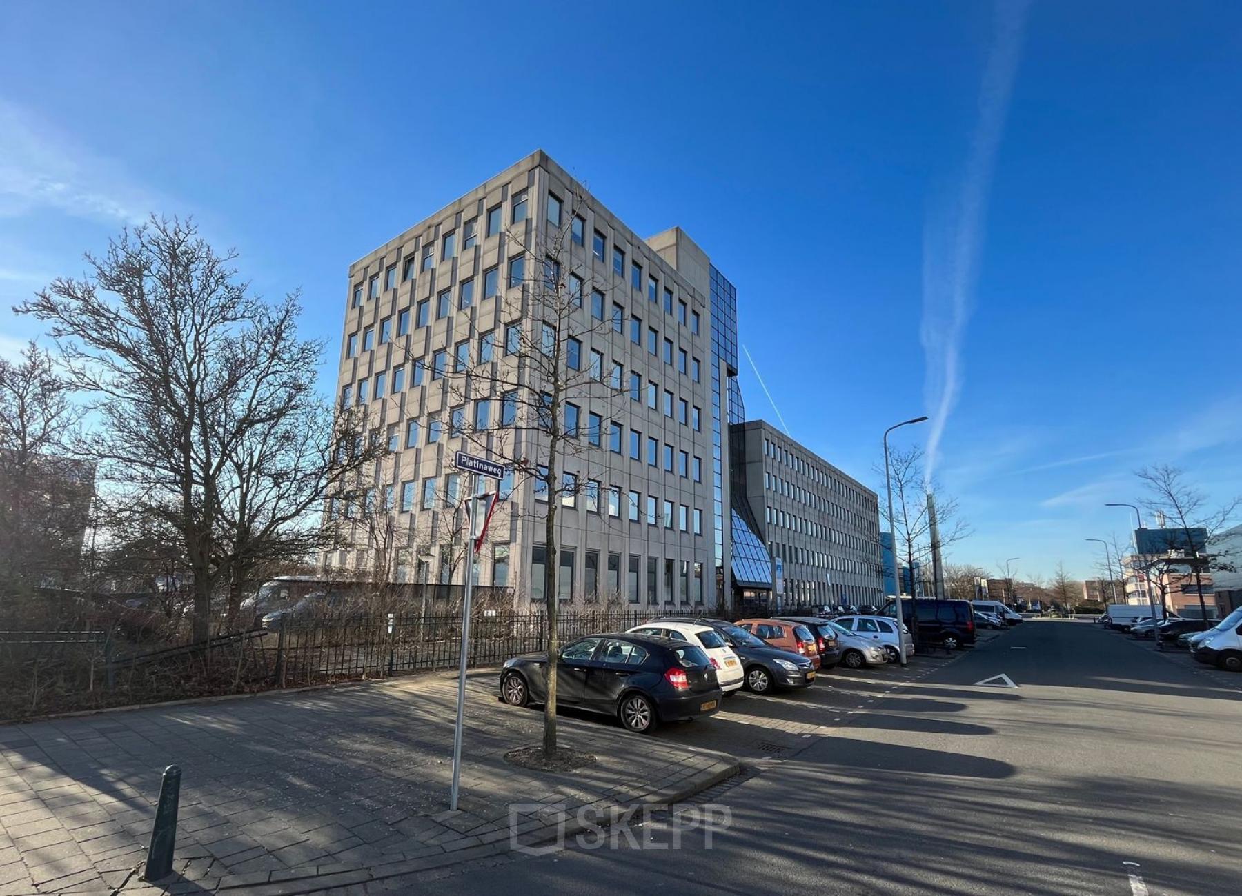 Exterior view of an office building at Platinaweg 10, The Hague Escamp, featuring ample parking space in front of the building. Ideal for office space rental or office to rent enthusiasts.