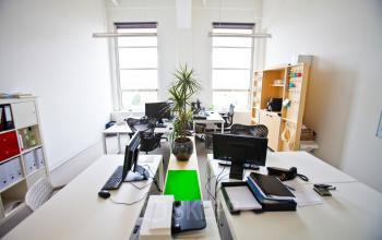 Sleek and modern office space rental at Zuid Hollandlaan 7, The Hague Haagse Hout, featuring workstations with computers and vibrant green accents.