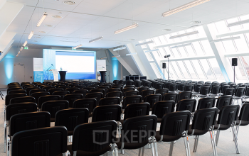 Modern conference room at Zuid Hollandlaan 7, The Hague Haagse Hout with rows of chairs facing a presentation screen, ideal for an office space rental.