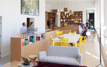 Modern office space rental at Zuid Hollandlaan 7, The Hague Haagse Hout, with vibrant furniture and busy professionals in a dynamic setting.