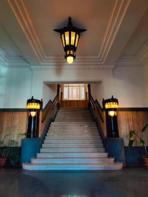 Interior photo of a well-lit entrance with a grand staircase and wooden accents, ideal for rent office space in The Hague.