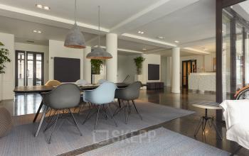 Modern, furnished office space featuring a large table with stylish chairs and contemporary lighting, located at Bezuidenhoutseweg 161, The Hague Haagse Hout, available for rent. Ideal for collaborative work.