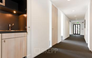 Modern office space at Bezuidenhoutseweg 161, The Hague Haagse Hout with sleek design, available for rent. Features ample corridors and a kitchenette for an effective office space rental.