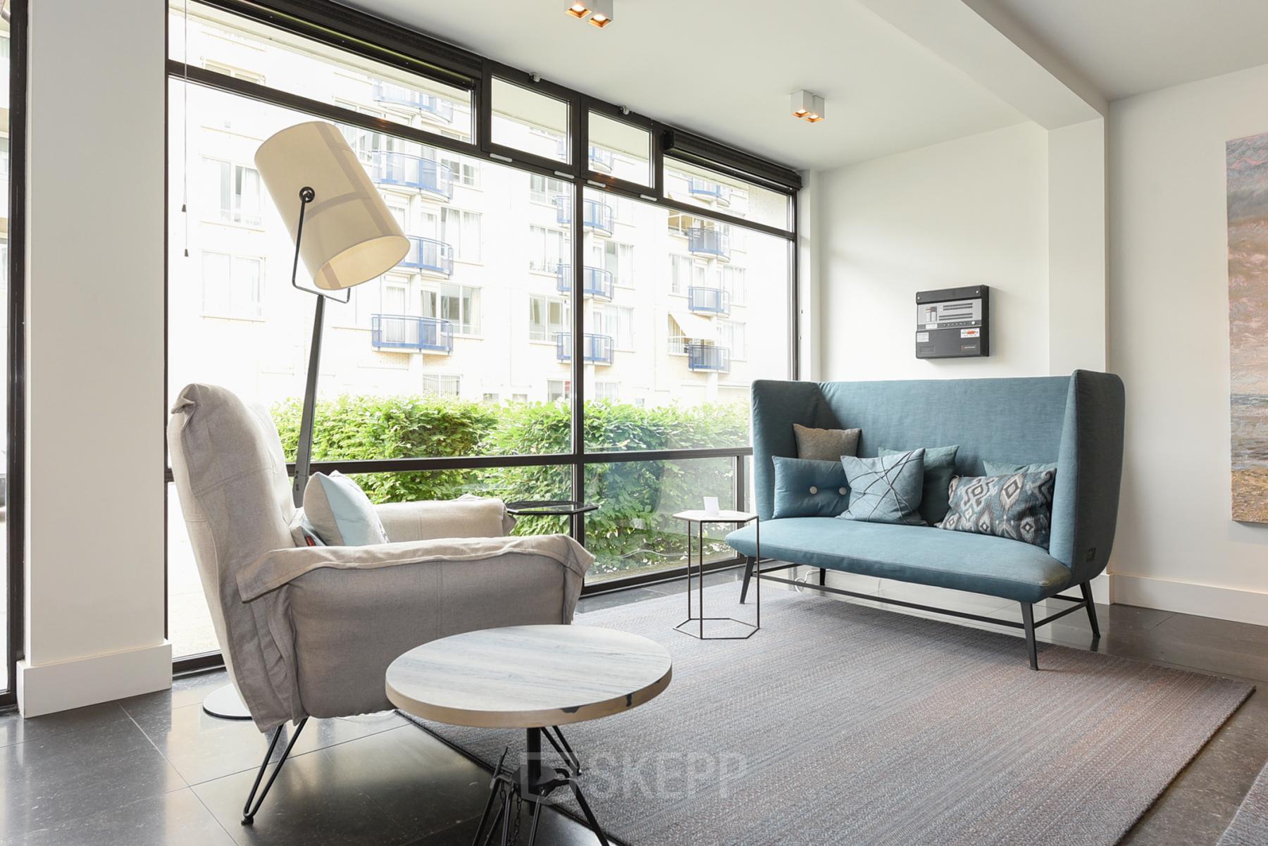 Modern furnished office lounge area at Bezuidenhoutseweg 161, The Hague Haagse Hout, offering comfortable seating and views, ideal for office space rental.