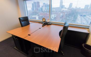Professional office space rental in The Hague Haagse Hout at Jan Pietersz. Coenstraat 7 with a neatly organized work desk and city view.