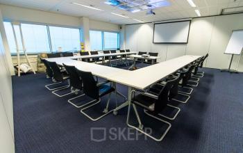 Spacious office space rental at Jan Pietersz. Coenstraat 7, The Hague Haagse Hout, with a large conference table and bright lighting.