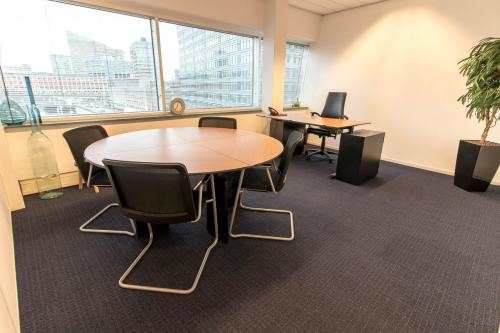 View of a well-lit office space rental at Jan Pietersz. Coenstraat 7, The Hague Haagse Hout, with a round table and chairs.