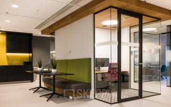 Modern office interior at Prinses Margrietplantsoen 25, The Hague Haagse Hout, featuring sleek workspaces with glass partitions and vibrant furnishings, ideal for office space rental.