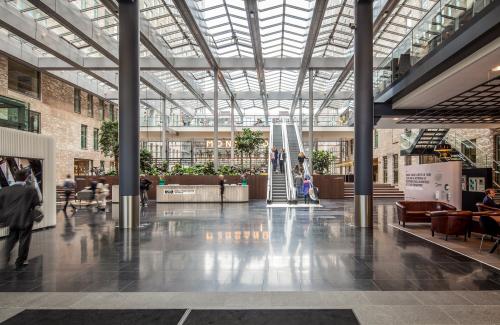 Spacious interior of Prinses Margrietplantsoen 25 in The Hague, showcasing a modern open floorplan with sleek flooring, comfortable seating, and green accents; perfect for office space rental.