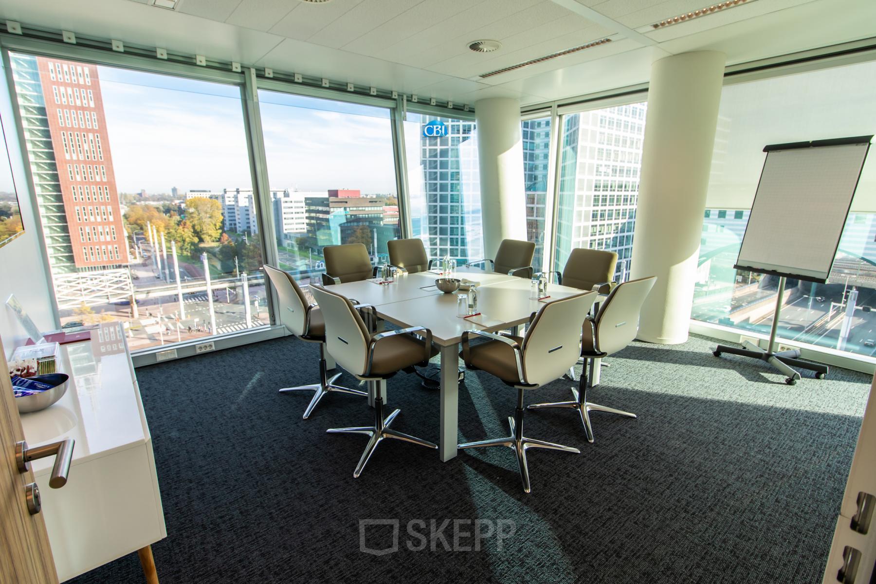 A bright conference room with a large table and chairs, offering a view over The Hague from Schenkkade 50. Ideal for office space rental.