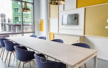 Modern conference room with a long table, chairs, TV, and large windows in an office to rent at Oude Middenweg 3-19, The Hague.