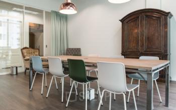 Modern office space rental at Oude Middenweg 3-19, The Hague, featuring a stylish meeting room with a combination of classic and contemporary furniture.