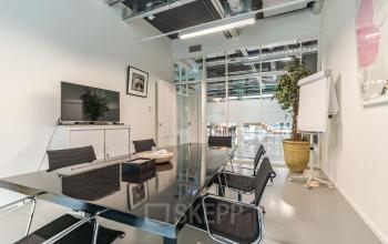 Modern office space rental at Oude Middenweg 3-19 in The Hague with sleek furnishings and a communal vibe.