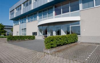 Exterior view of office space rental at De Rijn 18-22 in The Hague Leidschenveen-Ypenburg, featuring a modern building facade with clear glass windows.