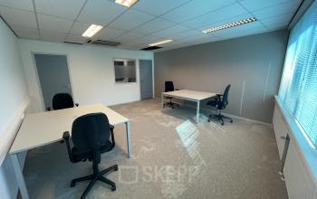 Well-lit office space rental at Oder 20, The Hague Leidschenveen-Ypenburg with desks, chairs, and a storage cabinet.