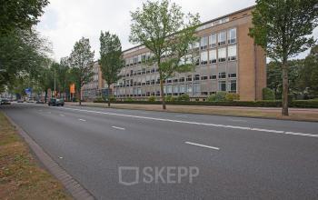 Exterior view of the office building available for office space rental at President Kennedylaan 19, The Hague, showing the building's facade.